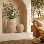 Woven decorative vases with eucalyptus branches in an arched wall niche
