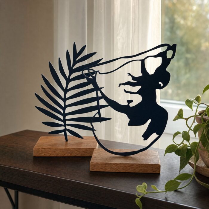 Palm Leaf & Face Silhouette Metal Table Sculptures on Wooden Base in a living space